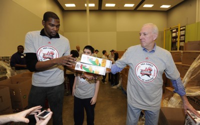 HOUSTON, TX - FEBRUARY 15: Kevin Durant of the Oklahoma City Thunder helps out with Head Coach Gregg Popovich of the San Antonio Spurs pass boxes of cereal at the 2013 NBA Cares Day of Service at the Food Bank sorting on February 15, 2013 in Houston, Texas. NOTE TO USER: User expressly acknowledges and agrees that, by downloading and/or using this photograph, user is consenting to the terms and conditions of the Getty Images License Agreement.  Mandatory Copyright Notice: Copyright 2013 NBAE (Photo by Bill Baptist/NBAE via Getty Images)